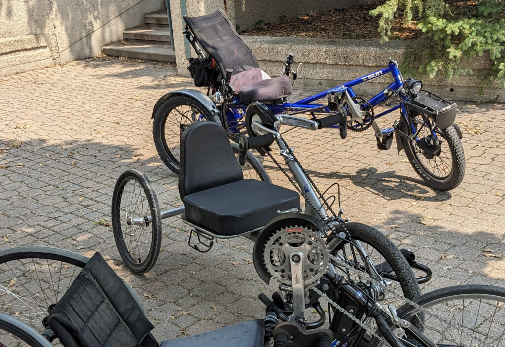 3 handcycles on a brick patio